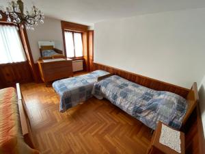 um quarto com uma cama e piso em madeira em Appartamento Proasch em Issime