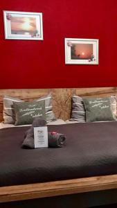 a bed with two pictures on a red wall at Komfort-Ferienwohnung Dreilaendereck in Ochtrup