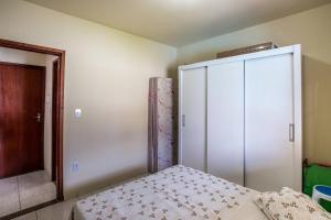 a bedroom with a bed and a large closet at Casa com piscina, wifi e churrasqueira em unamar. in Tamoios