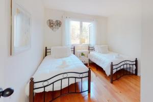 1 dormitorio con 2 camas y ventana en Heavenly Lakefront, en Plymouth