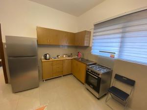 a kitchen with wooden cabinets and a stainless steel refrigerator at Horses House in Kerak