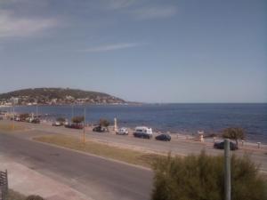 Une route à côté de l'océan avec des voitures. dans l'établissement Cómodo apartamento frente al Mar, à Piriápolis