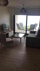 1 dormitorio con 1 cama, mesa y sillas en Cómodo apartamento frente al Mar, en Piriápolis