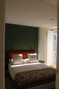 1 dormitorio con 1 cama grande y pared verde en Villa Graça -Hostels and Apartments en Santarém