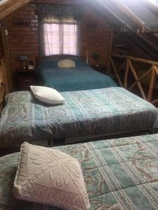 1 dormitorio con 2 camas en una cabaña de madera en Cabaña a orillas del Lago, en Tarija