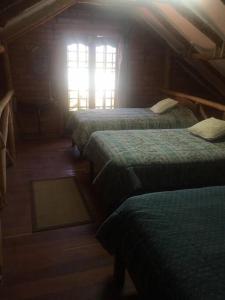 a room with three beds and a window at Cabaña a orillas del Lago in Tarija