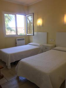 Dos camas en una habitación con dos ventanas. en Casa buganvilla, en Almarda 11 fotos más