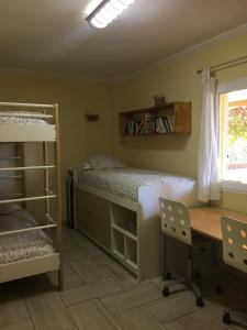 1 dormitorio con escritorio, 1 cama, escritorio y sillas en Casa buganvilla, en Almarda