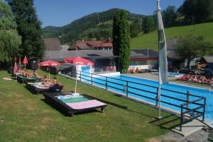 a group of people sitting around a swimming pool at Landhotel-Restaurant Willingshofer in Gasen