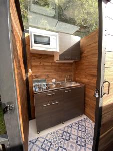uma cozinha com um lavatório e um micro-ondas em MAUNA Glamping em Tenjo