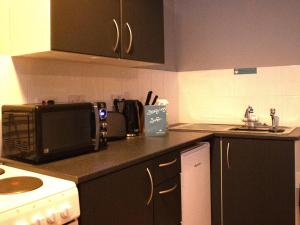 uma cozinha com um micro-ondas e uma bancada em Paul's Studio @ Liver House em Rock Ferry