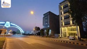 una calle de la ciudad con un edificio y un puente en Multazam Heights, DHA Phase 8, en Lahore