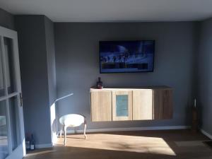 a living room with a cabinet and a white chair at ihle-huimat in Oberstdorf