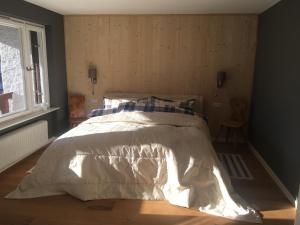a bedroom with a bed with a white comforter and a window at ihle-huimat in Oberstdorf +19 photos