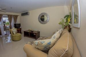 a living room with a couch and a mirror at Lantana Barbados Condos in Saint James