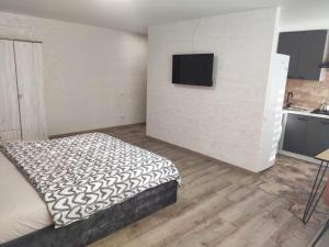 ein Schlafzimmer mit einem Bett und einem TV an der Wand in der Unterkunft Boulevard in Krementschuk