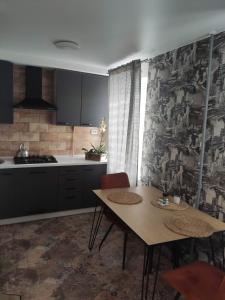 cocina con mesa y sillas en una habitación en Boulevard, en Kremenchuk