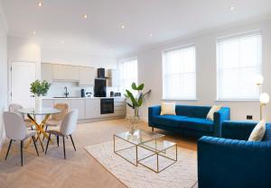斯卡伯勒The Salisbury - Luxury Apartments by Stay In Scarborough的客厅里有一张蓝色的沙发和一张桌子