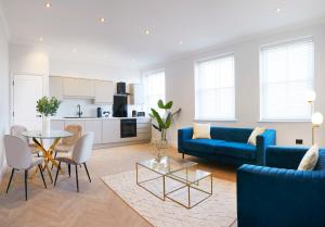 een woonkamer met een blauwe bank en een tafel bij The Salisbury - Luxury Apartments by Stay In Scarborough in Scarborough
