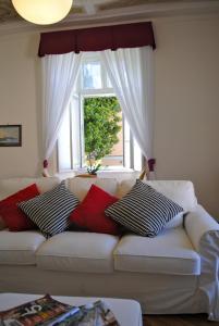 Sofá blanco con almohadas frente a una ventana en Suite Villa Lillia, en Bellagio