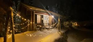 a house covered in christmas lights in the snow at Rukan Ukkoteeri 1 & 2 in Ruka