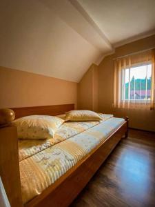 a large bed in a room with a window at Cabana Izvorul Ariesului in Vartop