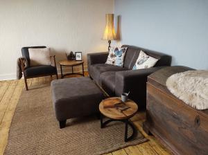 ein Wohnzimmer mit einem Sofa und einem Stuhl in der Unterkunft Minicamping und B&B Apartment Hintergarten in Niederorschel