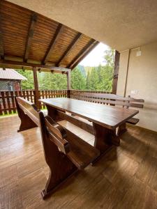 una gran mesa de madera y sillas en una terraza en Cabana Izvorul Ariesului, en Vartop