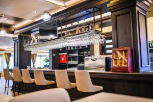 a bar with a row of white chairs and a counter at Zlatna Kruna in Banja Luka