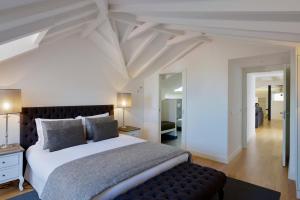 a bedroom with a large bed with a black leather couch at FLH Luxus Santa Catarina in Lisbon