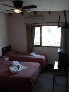 
a bedroom with two beds and a television at Hotel Verde Sol in Villa Carlos Paz
