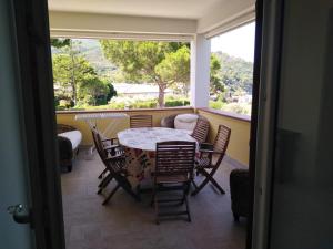 balcone con tavolo, sedie e finestra di Casa Vacanze De Simone San Marco di Castellabate a Castellabate