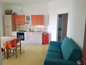 un soggiorno con divano blu e una cucina di Casa Vacanze De Simone San Marco di Castellabate a Castellabate