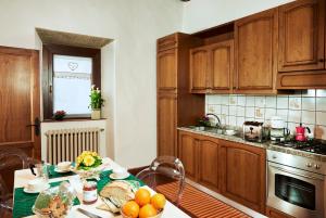 a kitchen with wooden cabinets and a table with fruit on it at Casa Lavanda Panzano in Chianti in Greve in Chianti