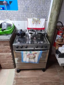 a stove with pots and pans on it in a kitchen at Suítes no Refúgio da Mata Atlântica - Sobrado Centenário in Torres