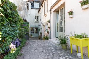 an alley in a house with a yellow table and flowers at La Little Maison in Loches