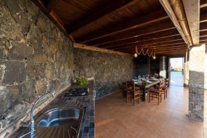 eine Küche und ein Esszimmer mit einer Steinmauer in der Unterkunft Villa Sara Fuerteventura in Cardón