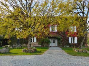 uma casa com uma árvore em frente em Domaine de Panissac em Berneuil