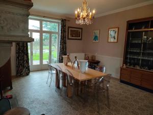 a dining room with a table and chairs and a chandelier at Domaine de Panissac in Berneuil