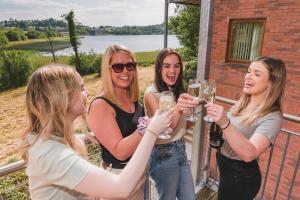 un grupo de mujeres sosteniendo copas de champán en Enniskillen Watersedge Apartments, en Enniskillen