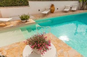 una piscina con sedie e un tavolo con fiori di Casa de lidzia2 a Cisternino