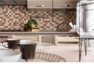 una cucina con tavolo, sedie e lavandino di Casa de lidzia2 a Cisternino