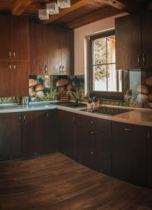 a kitchen with wooden cabinets and a sink and a window at Glamping Pod Gwiazdami in Pietrusza Wola