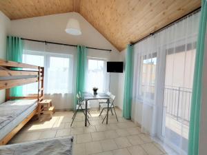 1 dormitorio con cama, mesa y ventanas en Willa Karwia en Karwia