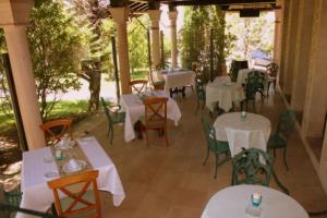 a dining area with tables, chairs and umbrellas at Mirasierra in Santo Tomé del Puerto