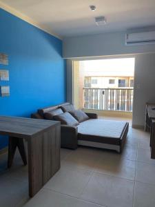 ein Wohnzimmer mit einem Sofa und einem Tisch in der Unterkunft Apartamento Ondas Praia Resort in Porto Seguro