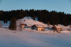 a group of buildings on a snow covered hill at Au Coeur de Prémanon in Prémanon