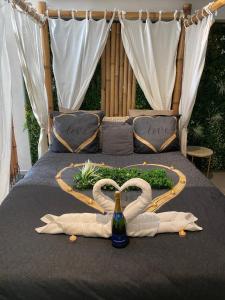 Dos cisnes forman un corazón en una cama en Magnifique love room avec jacuzzi privatif vue Mer, en Port-de-Bouc