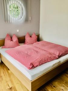 インメンシュタット・イム・アルゴイにあるVilla-marlonのベッド(赤と白のシーツ、枕付)