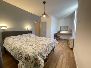 a bedroom with a bed and a desk in it at Gîte Le Layris in Campan